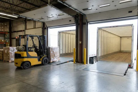 Forklift staging freight beside trailers